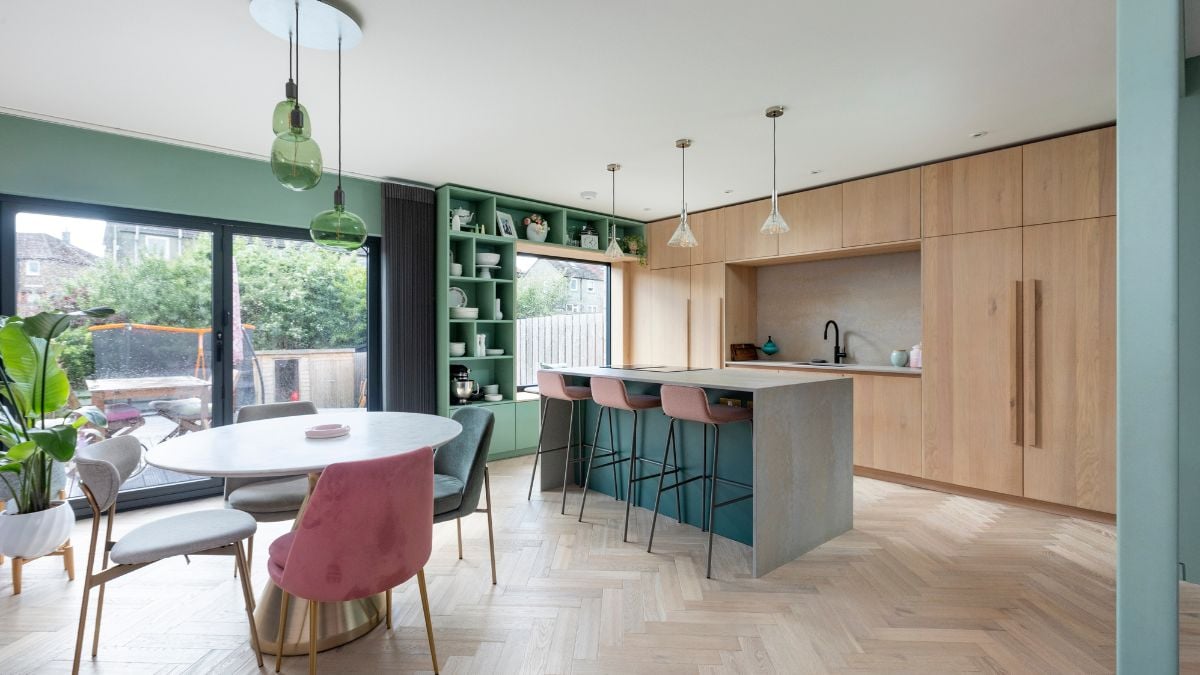 这是一张室内照片，展示了一个与相邻厨房区无缝融合的用餐区，创造了一个和谐而有凝聚力的生活空间。
