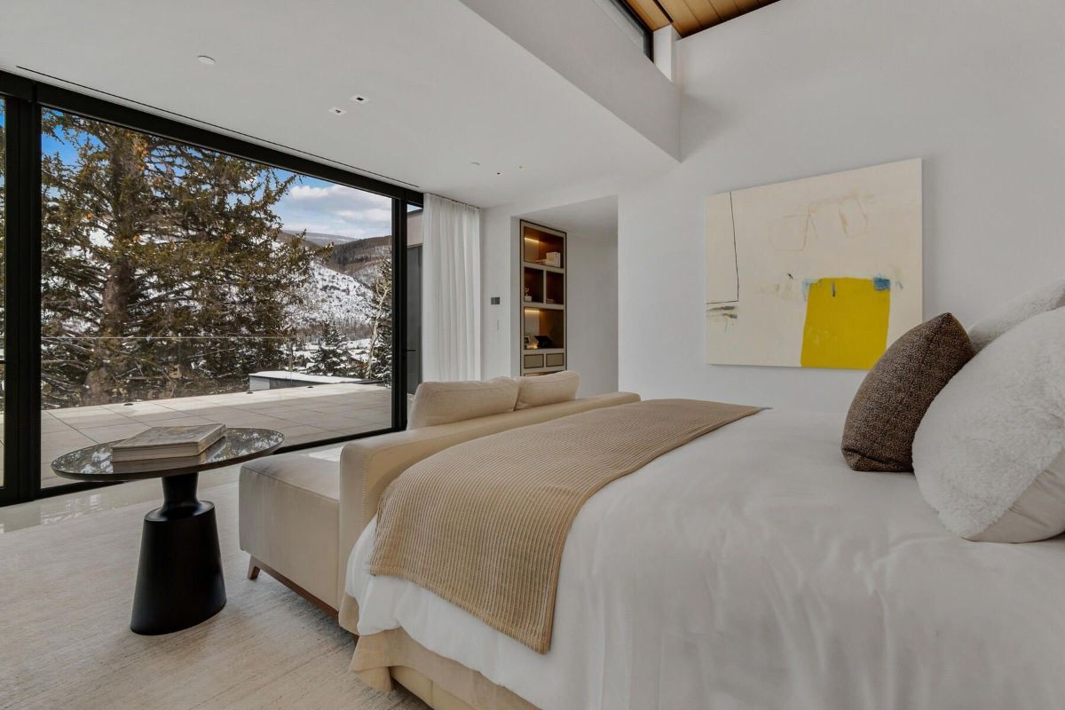 房间功能double-sized床和卧室的长椅上面临的玻璃墙外面展示一个优秀的视图。