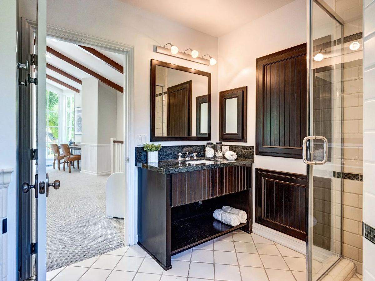 优雅的木质虚荣优雅地站在瓷砖地板上,和墙上的软发光光上面添加一个触摸的温暖和舒适浴室的氛围。