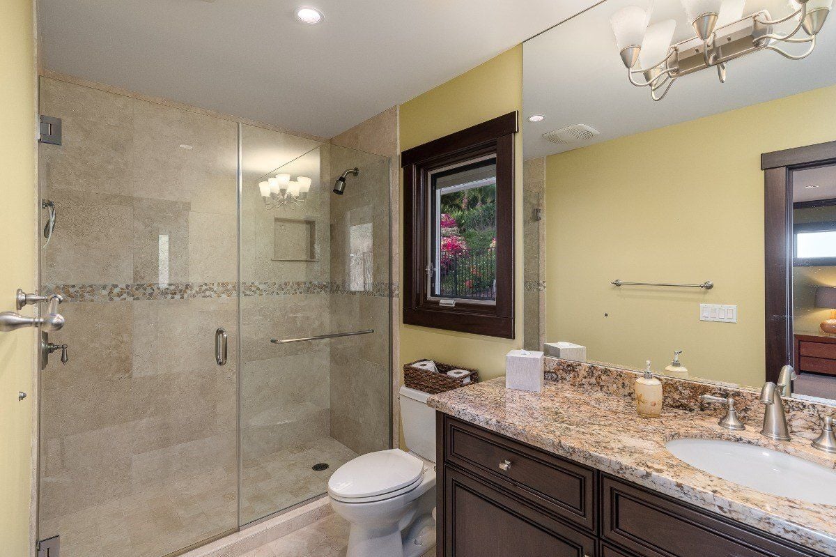 浴室设有一个带有花岗岩台面的梳妆台和一个带玻璃外壳的淋浴间。