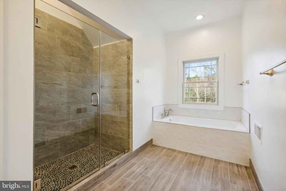 浴室设有一个内置浴缸和一个带玻璃外壳的淋浴间。