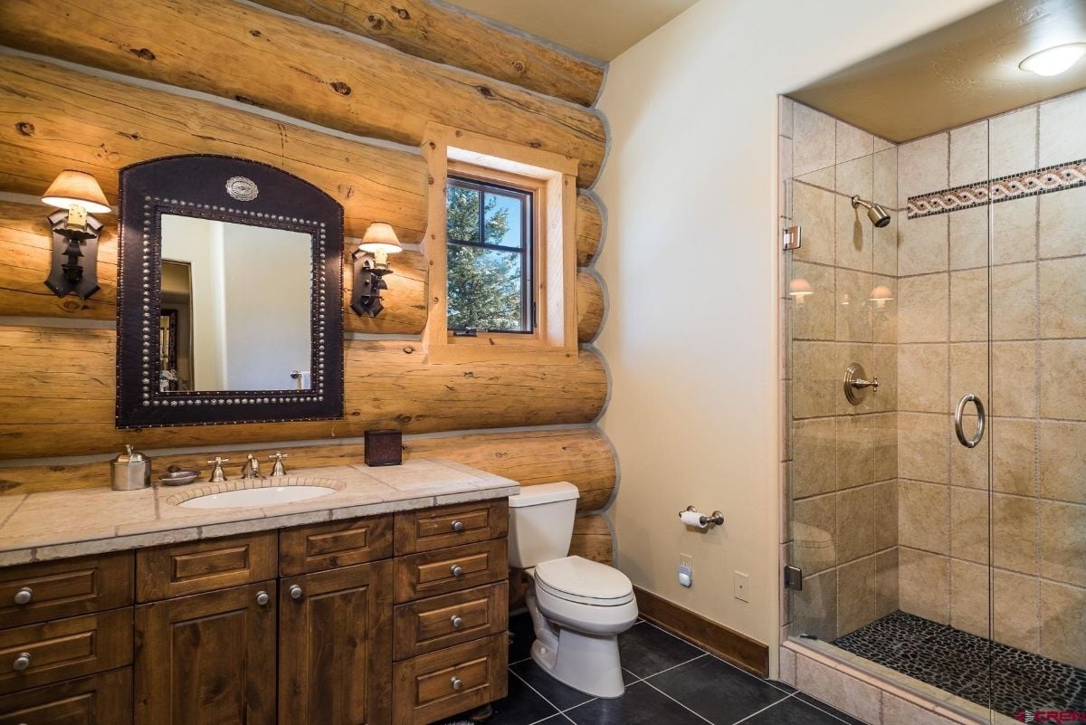 浴室有一个虚荣心瓷砖灶台和淋浴房玻璃外壳。