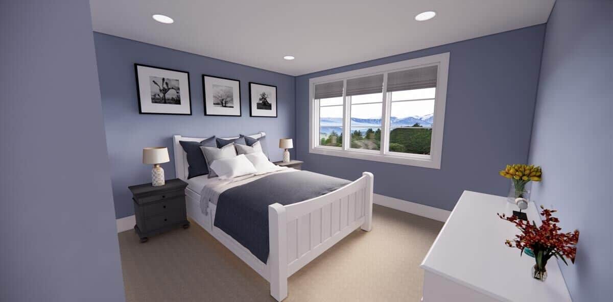 这间卧室有一张白色的床，一个匹配的梳妆台，柔和的蓝色墙壁装饰着框架艺术品。