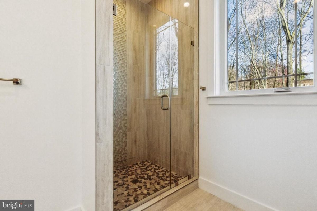 浴室设有带玻璃门和瓷砖墙的淋浴间。