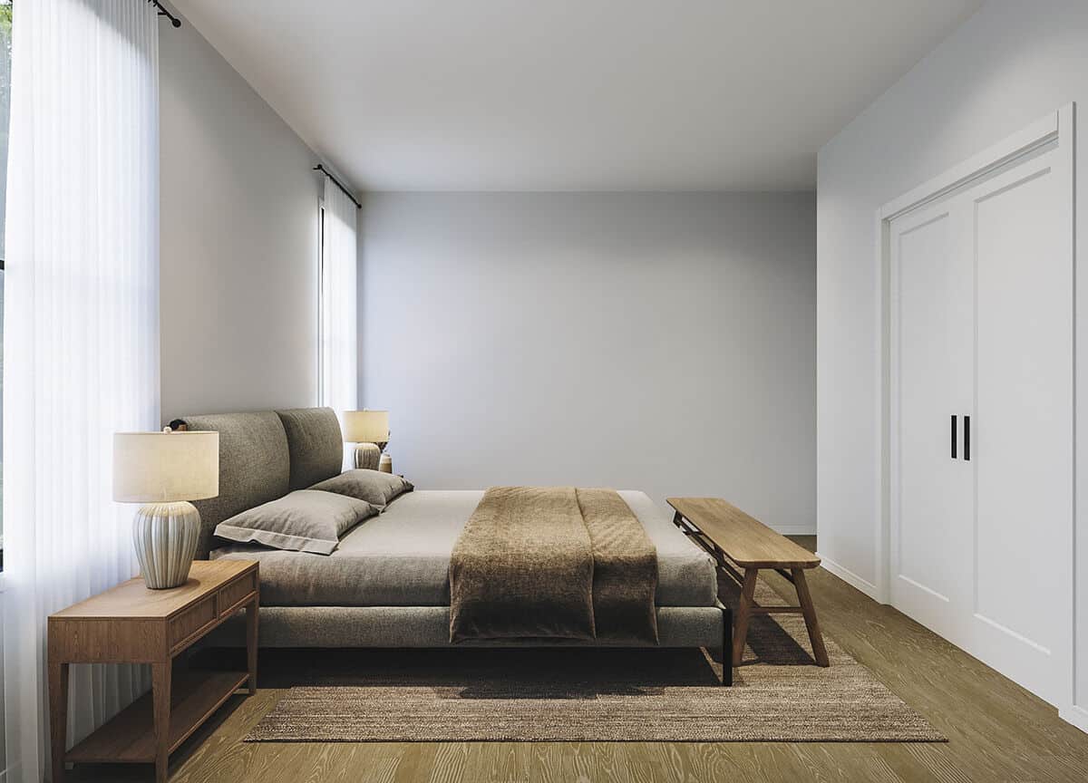 主卧室有一个步入式衣橱和一张舒适的平台床，配有一张木凳。