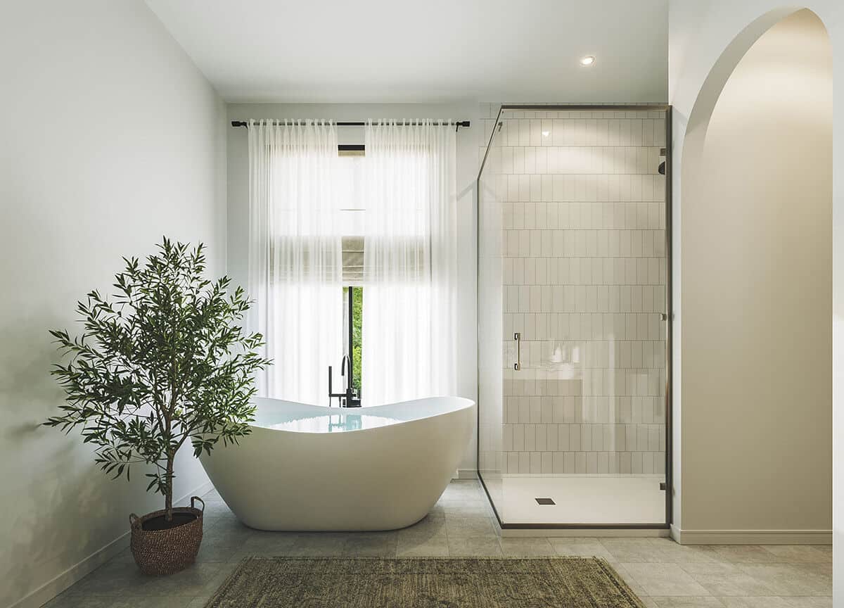 大型盆栽植物在深浸泡浴缸旁边添加一个热带氛围到主浴室。