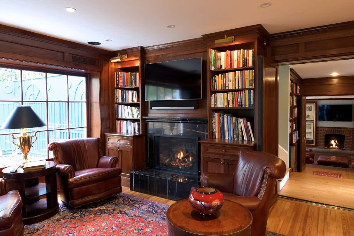 一间镶木板的图书室，内有真皮座椅和一座原装壁炉。