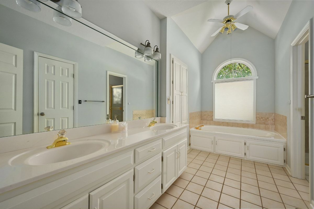 浴室设有一个嵌入式浴缸和一个带瓷砖台面的浮动梳妆台。