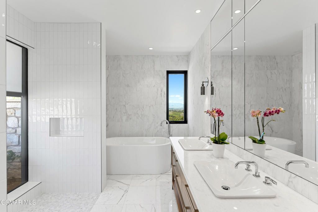 豪华的浴室配备了一个独立的浴缸，可以让人尽情放松，还有一个时尚的水槽，完美地补充了整体设计，提供了功能性和美感。