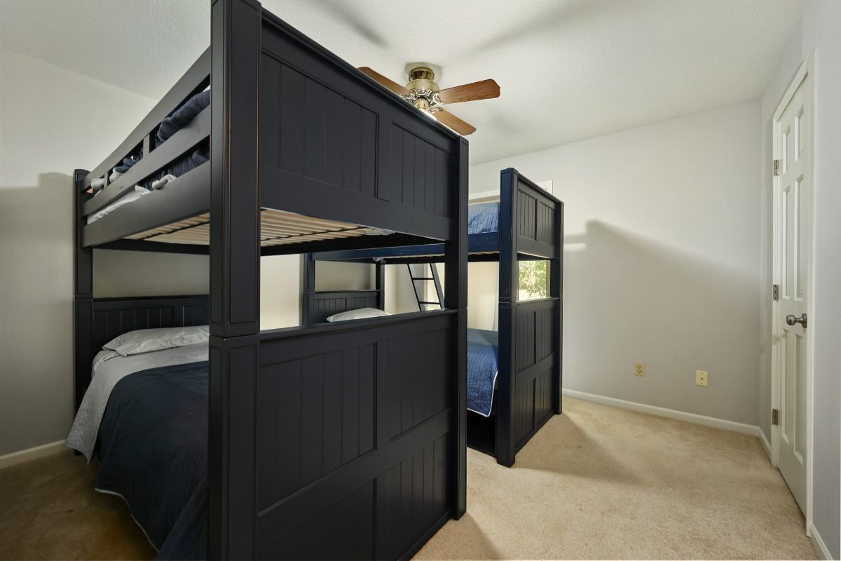 舒适的卧室配有两张双层床和一面墙的地毯，提供了一个舒适和诱人的空间，让你睡个好觉。