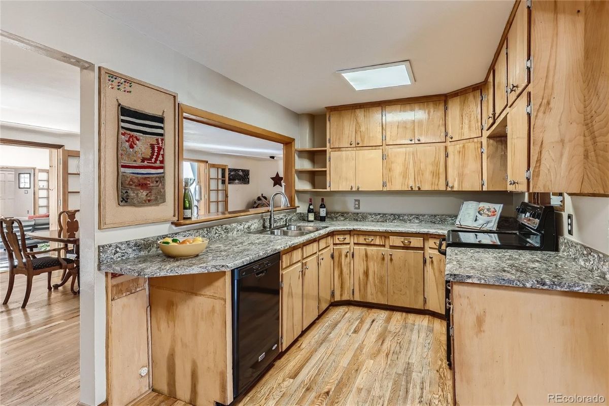 厨房呈u形布局，配有花岗岩台面和木制橱柜。