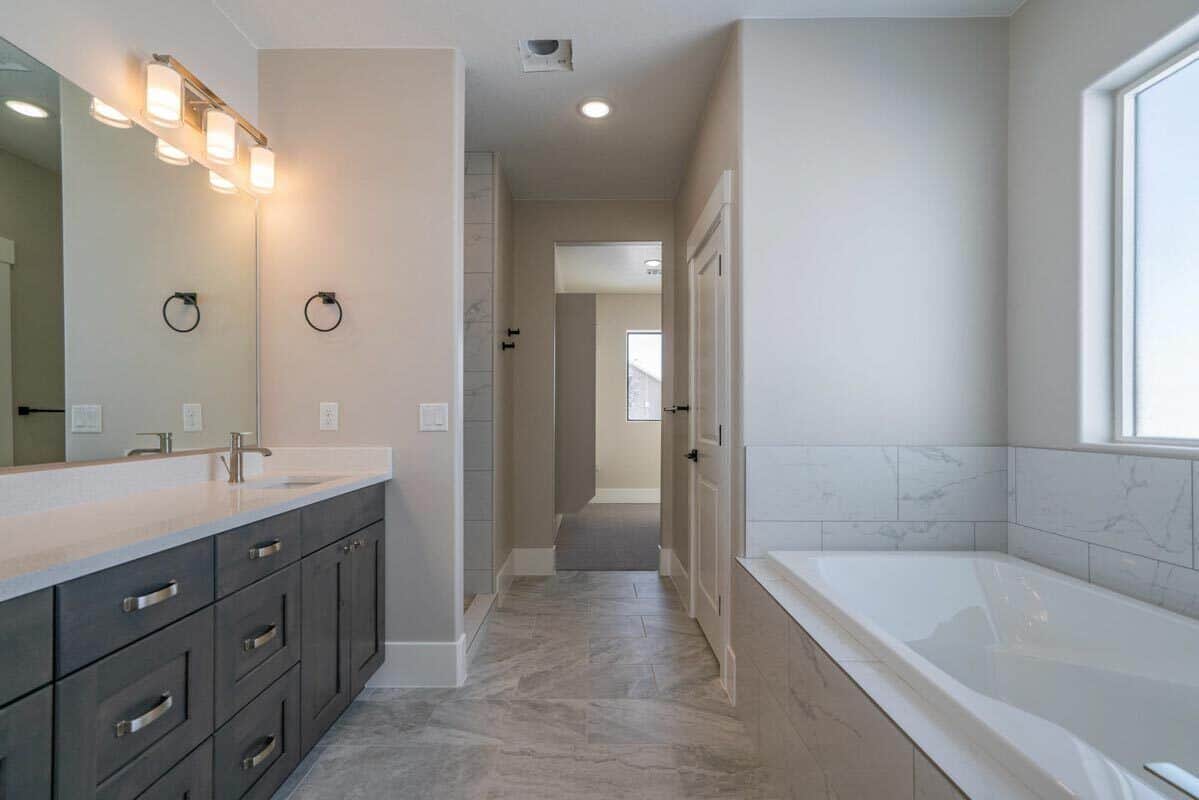 主浴室有一个双水槽虚荣和dropin浴缸里铺着白色大理石砖。