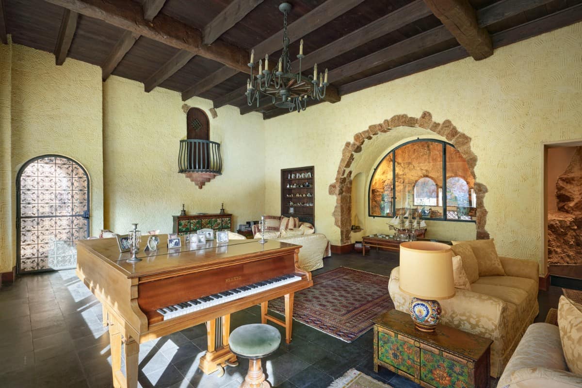 客厅里包括多个座位区域和古董钢琴。