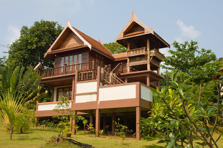 泰国的木制海滩别墅，热带树木散落在整个院子和高架覆盖的甲板上