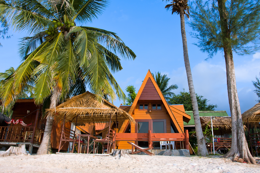 沙滩上有棕榈树的经典a型房屋