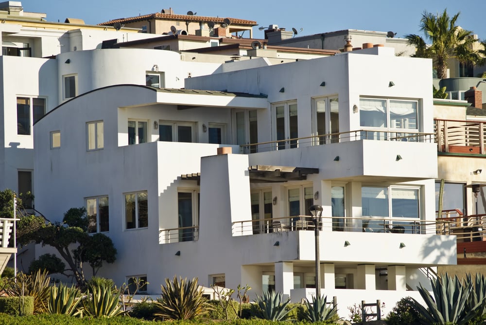 现代山坡上的三层白色海滨别墅，每层都有甲板